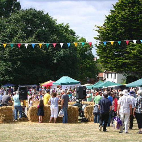 Westleton, Suffolk, England - August 18, 2013: visitors of all ages enjoying the sunshine at the annual Barrel Fair in this picturesque English village on Suffolk's Heritage Coast. In addition to the barrel races, the fete has games and traditional entertainment for all the family, craft stalls, and food and drink stands.